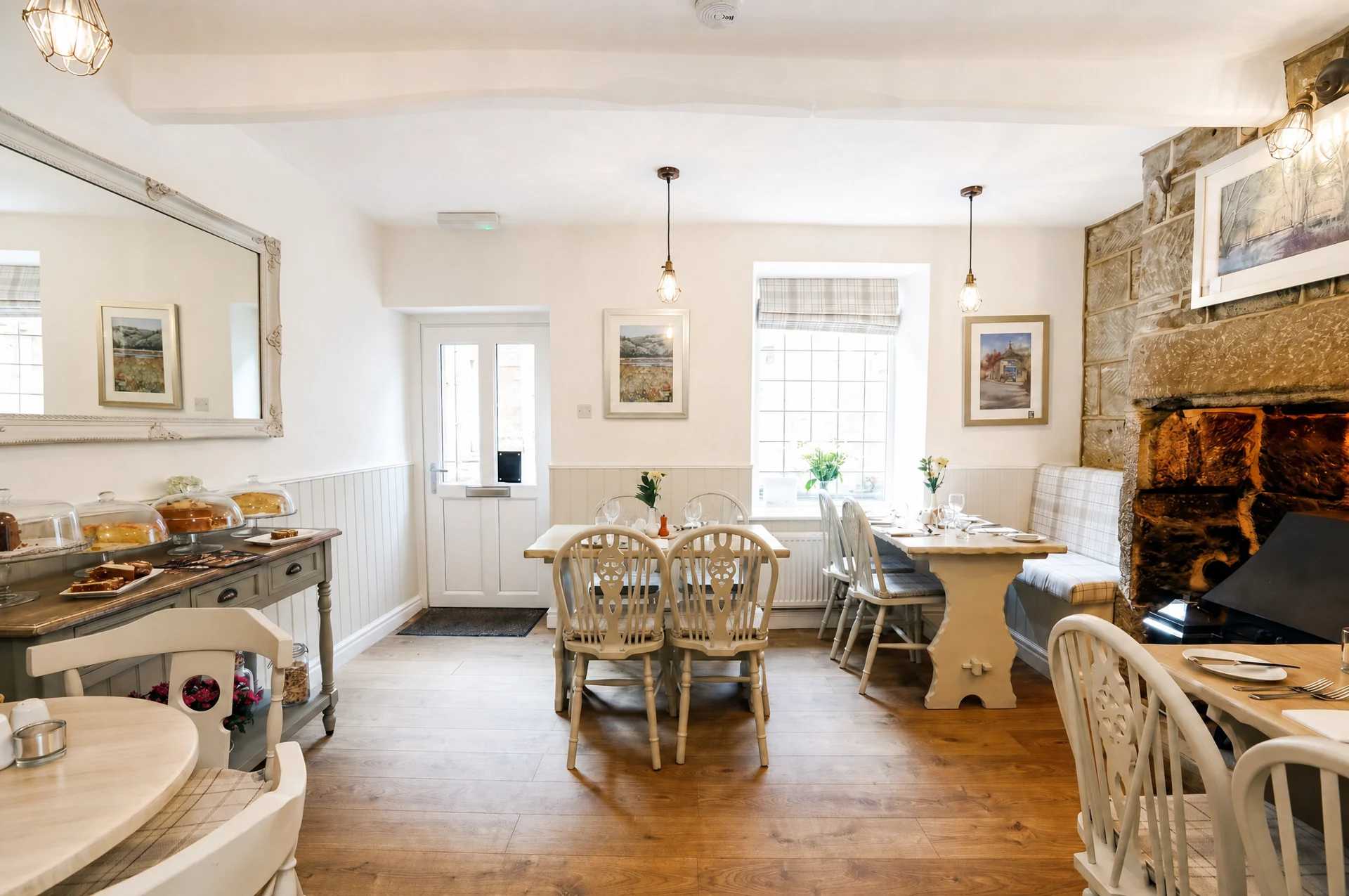 The Willow’s dining room, with white wooden chairs and its stone fireplace